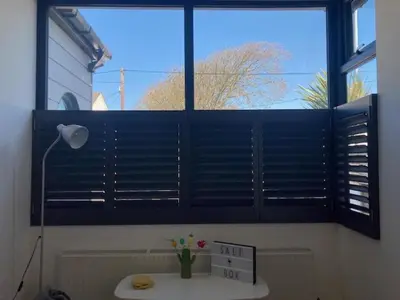 a window in a room with a table and a window with a vase at The Salt Box- Lovely refurbished annexe, free parking, walk to Porth beach. in Saint Columb Minor