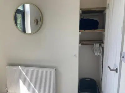 a mirror on the wall of a bathroom with a toilet at The Salt Box- Lovely refurbished annexe, free parking, walk to Porth beach. in Saint Columb Minor