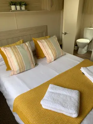 a large bed with pillows and a white towel on it at Newquay Bay Resort 63 in Porth