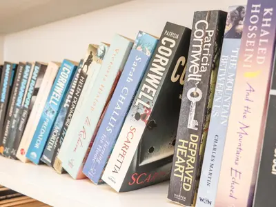 a row of books sitting on a shelf at Higher Kernick View in Bodmin