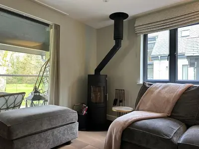 a living room with a couch and a wood stove at Primrose in Bodmin