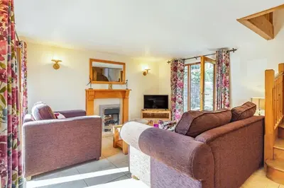 a living room with two couches and a fireplace at Miller's Lodge in Liskeard