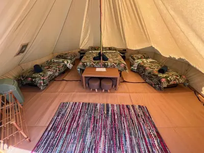 a room with three beds and a table in a tent at The Laurels Holiday Park & Cottages nr Padstow and Wadebridge in Wadebridge