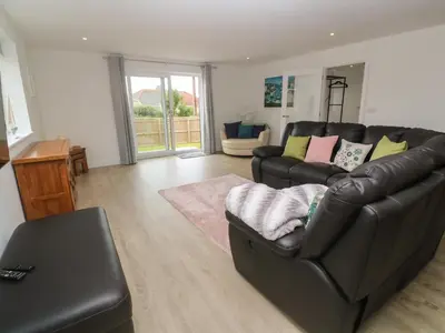 a living room with a black leather couch at 3 Praa Cove in Penzance