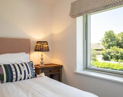 a bedroom with a bed and a window at Artemis in Saint Minver
