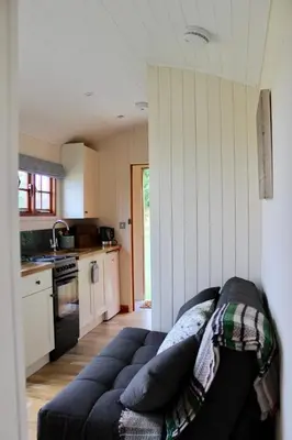 a living room with a couch in a kitchen at Hare's Hut in Saint Clement