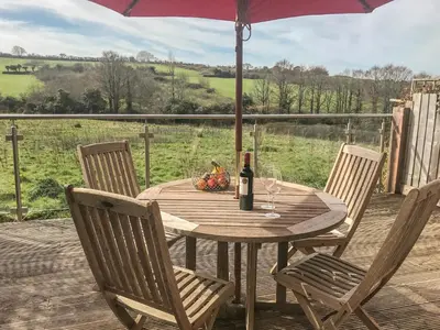 a wooden table with a bottle of wine and a glass at Maple in Falmouth