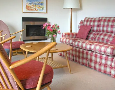 a living room with a couch and a table with flowers on it at Rosevallen in Polzeath