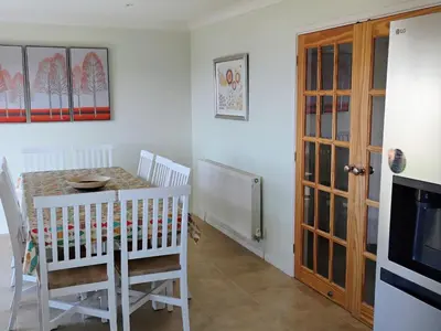 a dining room with a table and a television at Chy-An-Var in Polzeath