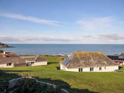 a view of a house with the ocean in the background at Upper Gren in Polzeath
