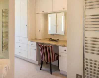 a kitchen with a counter with a chair and a mirror at Egloskerry in Wadebridge