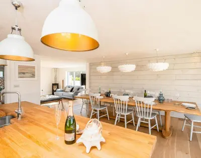 a kitchen and living room with a table and chairs at Seastar in Wadebridge