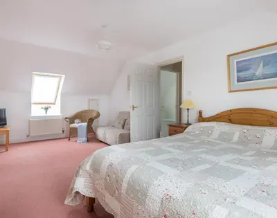 a bedroom with a bed and a couch at Kirra in Polzeath