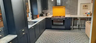 a large kitchen with blue cabinets and a stove at Newly Refurbished 2nd Floor Apartment Lil Nauti in Fowey