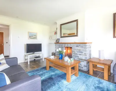 a living room with a couch and a fireplace at Lundy Cottage in Saint Minver