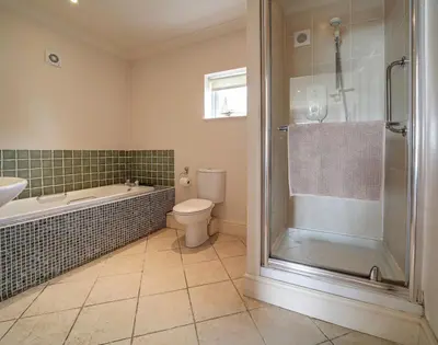 a bathroom with a shower and a toilet and a sink at Worthy House in Polzeath