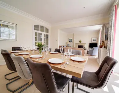 a dining room with a large wooden table and chairs at The Haven in Polzeath