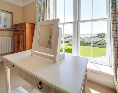 a tv sitting on a table in front of a window at The Haven in Polzeath