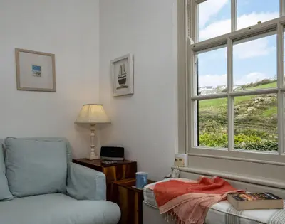 a living room with a chair and a window at April Cottage in Port Isaac