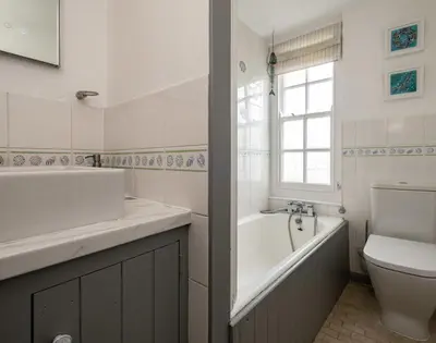 a bathroom with a tub and a sink and a toilet at April Cottage in Port Isaac
