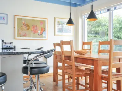 a kitchen and dining room with a wooden table and chairs at Beachside in Polzeath