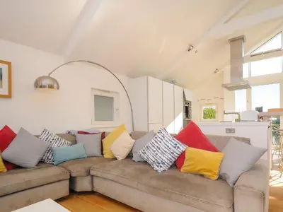 a living room with a couch with colorful pillows at Drishti in Polzeath