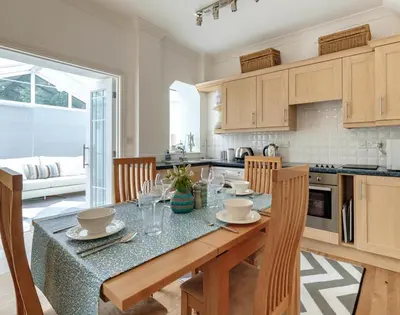 a kitchen with a table with chairs and a dining room at St Martins Apartment in Saint Minver