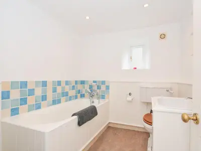 a bathroom with a tub and a toilet at Orchard Cottage in Saint Endellion
