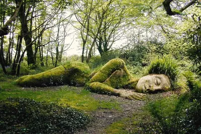 a statue of a person laying in the grass at Hillside in St Austell