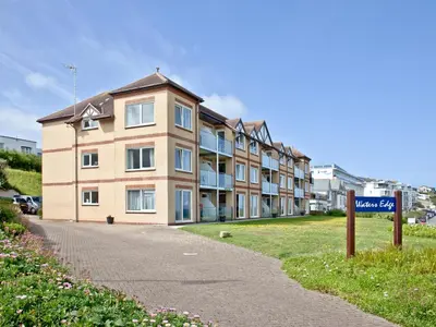 a building with a street sign in front of it at Apartment 1 Waterrs Edge in Crantock