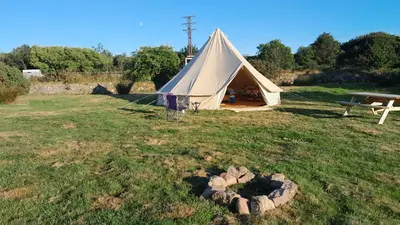 a large tent in a field with a picnic table at Cornish Skies Glamping in Pool