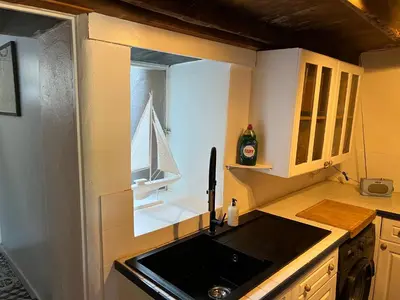 a small kitchen with a sink and a window at The Cottage St Kew in Port Isaac