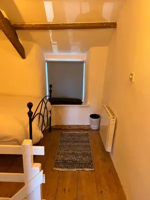 an attic room with a bed and a window at The Cottage St Kew in Port Isaac