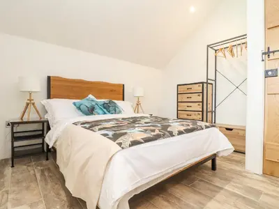 a bedroom with a large bed and a dresser at Polurrian House in Helston