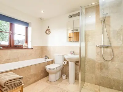 a bathroom with a toilet sink and a shower at Polurrian House in Helston