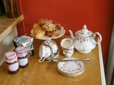 a table with a plate of cookies and a teapot at Hindscarth Apartment - Uk39610 in Davidstow