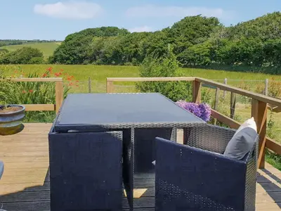 a black table and chairs on a wooden deck at Hindscarth Apartment - Uk39610 in Davidstow