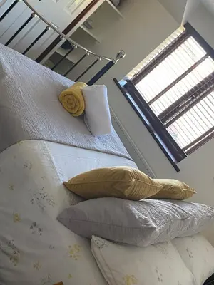 a bedroom with two beds with pillows and a window at Meadowview Cottage, Garden View in Camborne