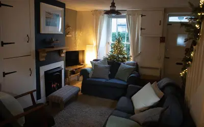 a living room with a christmas tree in the window at Brakestone Cottage in the heart of Port Isaac in Port Isaac