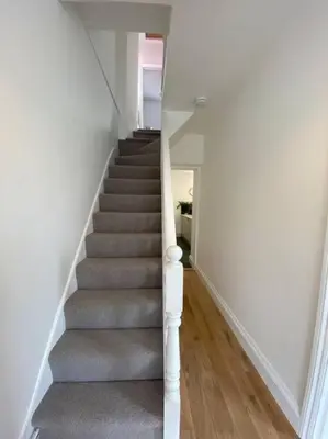 a staircase with grey carpet and white walls at Beautiful 2 bed end terrace Victorian town house in Redruth