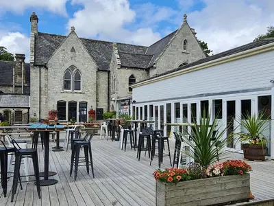 a patio with tables and chairs in front of a building at 3 Manor Villas Newquay in Newquay