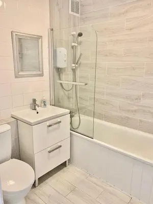a bathroom with a shower and a toilet and a sink at Towan Beach Holiday Flat in Newquay