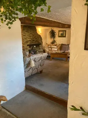 a living room with a stone fireplace and a couch at Bissick Old Mill in Truro