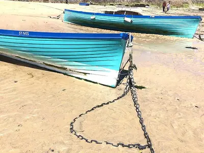 two boats tied up on a beach with a chain at The Grey Mullet Guest House in St Ives