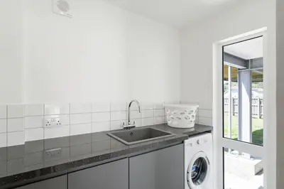 a kitchen with a sink and a washing machine at The Cube in Portreath