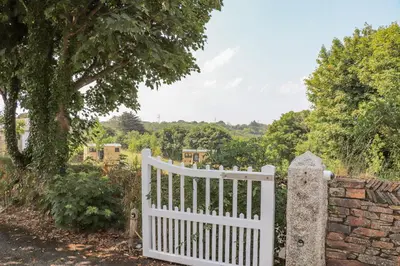a white gate in front of a stone wall at Rose in Redruth