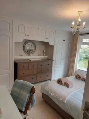 a bedroom with a bed and a sink and a mirror at Maen Lay, Gorran Haven in Gorran Haven