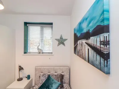a bedroom with a bed and a picture of a pier at The Hideaway in Chacewater