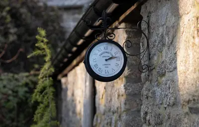 a clock hanging on the side of a building at The Lambing Shed, Cornwall in Altarnun