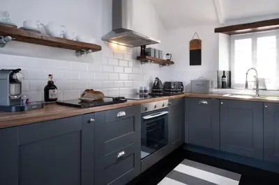 a kitchen with blue cabinets and a sink at The Lambing Shed, Cornwall in Altarnun